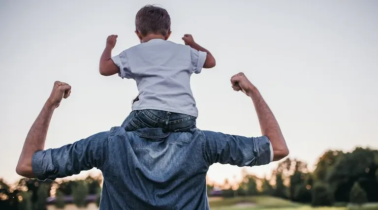 Father carrying child on shoulders - recovery and strength after shoulder surgery